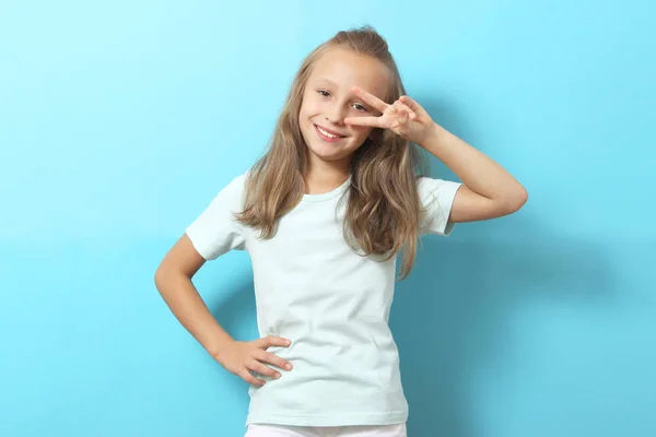 一个笑容可亲的小女孩穿着时髦的衣服 背景是彩色的 — 图库照片