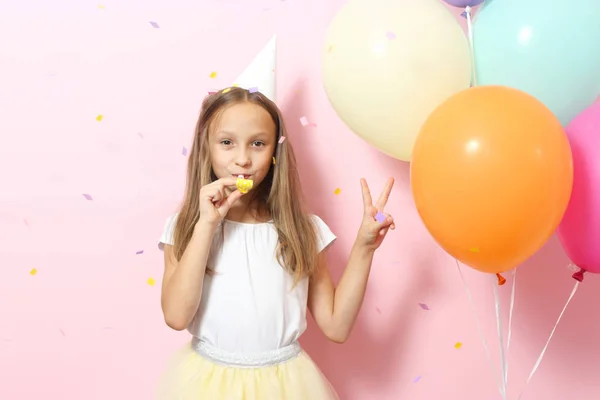 お祝いのキャップと色の背景に風船で小さなかわいい女の子の肖像画 誕生日 — ストック写真