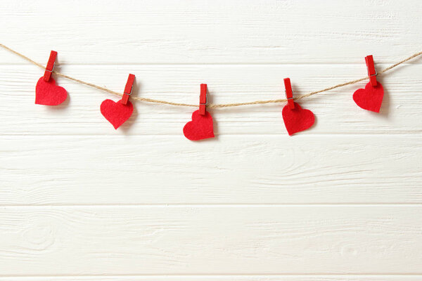 Hearts on a thread on a colored background. Garland of hearts. Valentine's day background