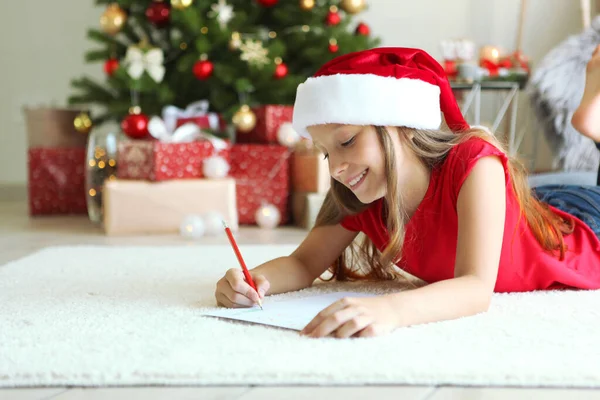 Noel arifesindeki küçük kız Noel Baba 'ya bir mektup yazıyor.