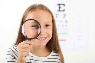 Tatlı küçük kız göz doktoruyla görüşünü kontrol ediyor. Görme testi