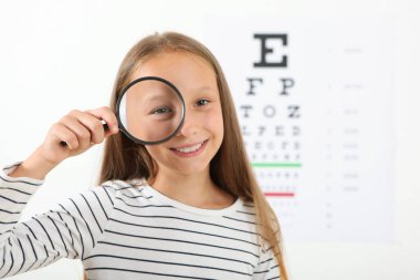Tatlı küçük kız göz doktoruyla görüşünü kontrol ediyor. Görme testi
