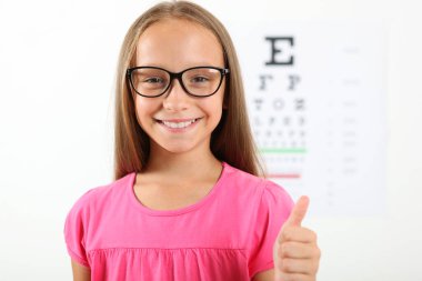 Tatlı küçük kız göz doktoruyla görüşünü kontrol ediyor. Görme testi