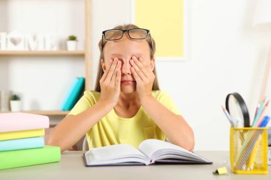 Küçük kızın gözlüğü yüzünden gözleri acıyor. Çocuklarda görme sorunları, görme düzeltmesi ve muayene.