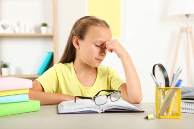 Küçük kızın gözlüğü yüzünden gözleri acıyor. Çocuklarda görme sorunları, görme düzeltmesi ve muayene.