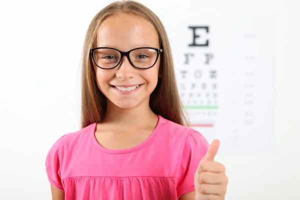 Cute little girl checks eyesight with an ophthalmologist. eyesight test