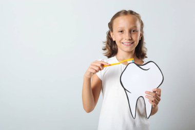 Küçük kız dişlerini banyoda fırçalıyor. Çocuklar için diş bakımı