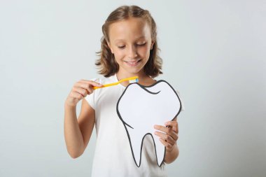 Küçük kız dişlerini banyoda fırçalıyor. Çocuklar için diş bakımı