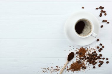 Kahve çekirdekleri ve kahve fincanı renkli arka planda metin için yer var.