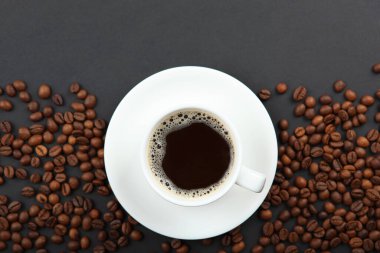 Kahve çekirdekleri ve kahve fincanı renkli arka planda metin için yer var.