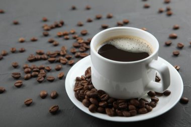 Kahve çekirdekleri ve kahve fincanı renkli arka planda metin için yer var.