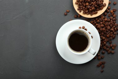 Kahve çekirdekleri ve kahve fincanı renkli arka planda metin için yer var.