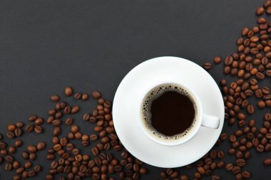 Kahve çekirdekleri ve kahve fincanı renkli arka planda metin için yer var.