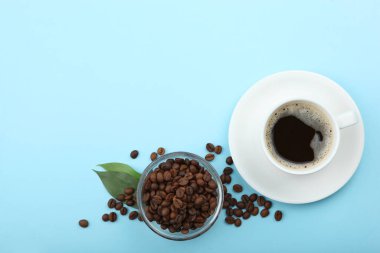 Kahve çekirdekleri ve kahve fincanı renkli arka planda metin için yer var.