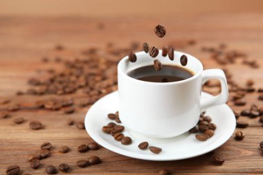 Kahve çekirdekleri ve kahve fincanı renkli arka planda metin için yer var.