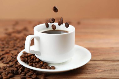 Kahve çekirdekleri ve kahve fincanı renkli arka planda metin için yer var.