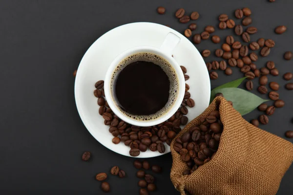 Kahve çekirdekleri ve kahve fincanı renkli arka planda metin için yer var.