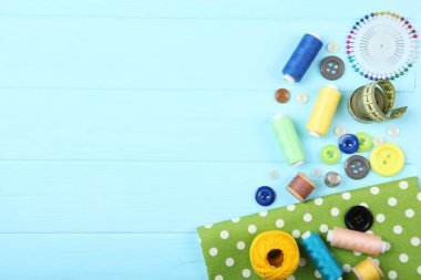 Masada farklı dikiş aksesuarları var. İplikler, iğneler, iğneler, iğneler, kumaş ve dikiş makasları kapatın.