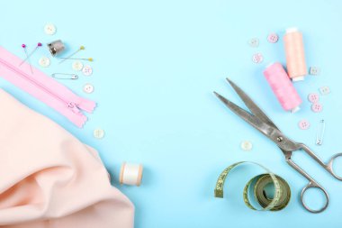 Masada farklı dikiş aksesuarları var. İplikler, iğneler, iğneler, iğneler, kumaş ve dikiş makasları kapatın.