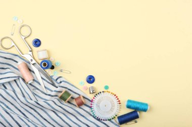 Masada farklı dikiş aksesuarları var. İplikler, iğneler, iğneler, iğneler, kumaş ve dikiş makasları kapatın.