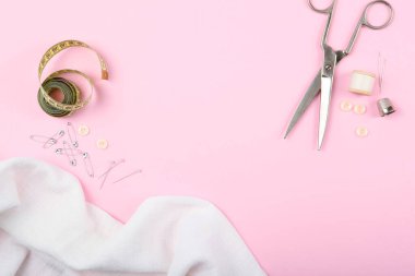 Masada farklı dikiş aksesuarları var. İplikler, iğneler, iğneler, iğneler, kumaş ve dikiş makasları kapatın.