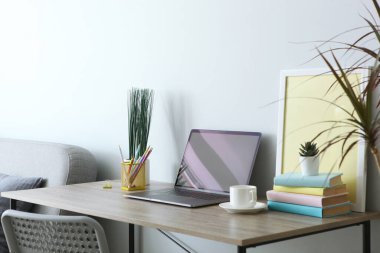 Odanın içinde modern dizüstü bilgisayarı olan bir işyeri.