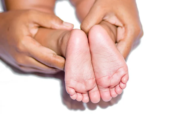 A mom holding baby’s two feet on a white background.
