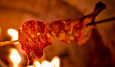 Bir demir sopa üzerinde kullanarak fırında tavuk kavurma olduğunu.