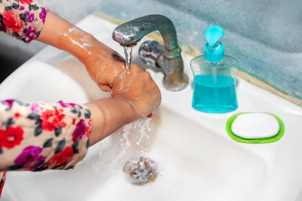 女性は水道水の下で手をこすり洗いするために液体石鹸を使用します 衛生概念 手を洗ってコロナウイルスの拡散を止める — ストック写真