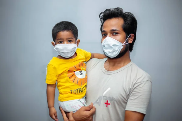 Genç bir adam ve küçük Asyalı çocuk Coronavirus 'un güvenliği için maske takıyor. Koronavirüs salgını.