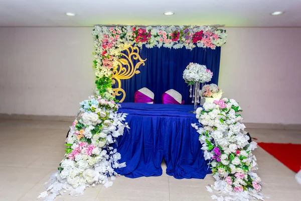 Artificial colorful paper flowers with navy-blue color based wedding stage decoration.