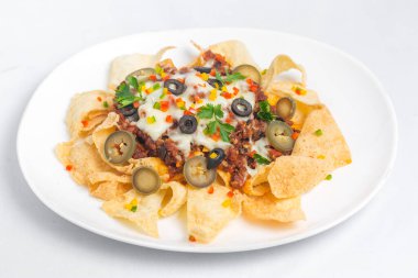 Meksika Meşhur Yemekleri Baharatlı Baharatlı Biftek Nachos. Eritilmiş peynirli ve jalapenolu kızarmış tortilla cipsleri abur cubur servisi yapar..