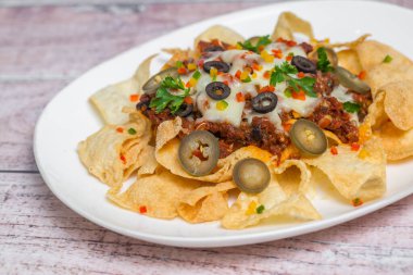 Meksika Meşhur Yemekleri Baharatlı Baharatlı Biftek Nachos. Eritilmiş peynirli ve jalapenolu kızarmış tortilla cipsleri abur cubur servisi yapar..