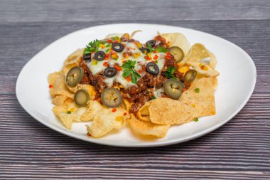 Meksika Meşhur Yemekleri Baharatlı Baharatlı Biftek Nachos. Eritilmiş peynirli ve jalapenolu kızarmış tortilla cipsleri abur cubur servisi yapar..