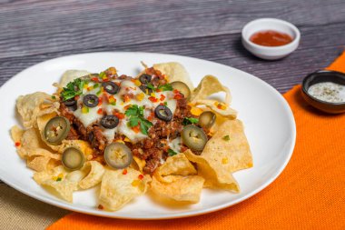 Meksika Meşhur Yemekleri Baharatlı Baharatlı Biftek Nachos. Eritilmiş peynirli ve jalapenolu kızarmış tortilla cipsleri abur cubur servisi yapar..