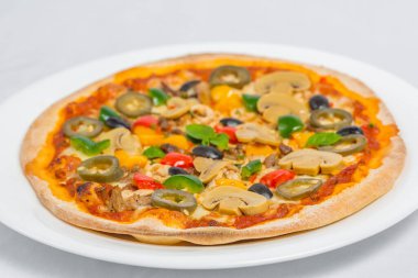 Beyaz arka planda izole edilmiş tavuk mantarlı biberli jalapeno ve kırmızı biberli pizza. Ev yapımı pizza..