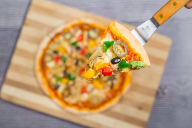 Yakın çekim ve tavuklu mantarlı jalapeno pizza dilimi ahşap kesme tahtasından alındı..