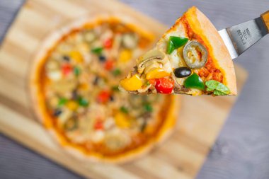 Yakın çekim ve tavuklu mantarlı jalapeno pizza dilimi ahşap kesme tahtasından alındı..