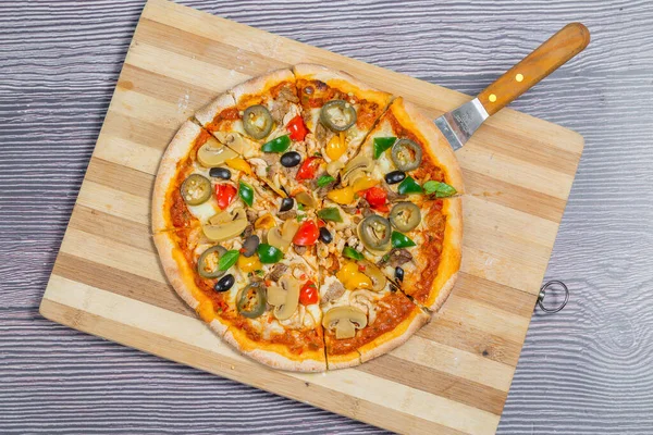 Sekiz parçaya bölünmüş mantarlı jalapeno pizza. Ev yapımı pizza..