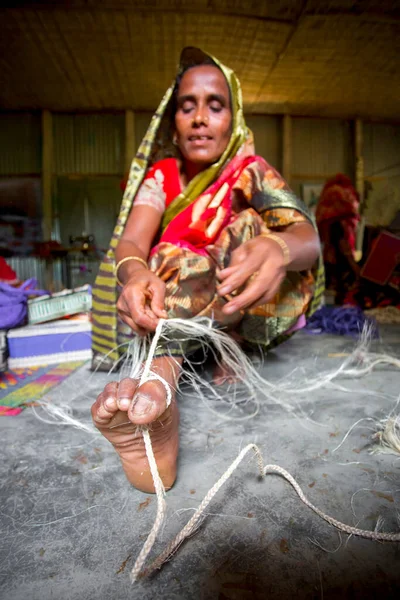 バングラデシュのタンゲイルのマドゥプルにある古代の方法で彼女の足の助けを借りてバナナの木の繊維からロープを作っています — ストック写真