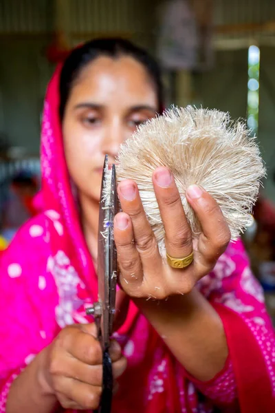 手工芸品を作る女性は バングラデシュのタンガイル州マドゥプルにあるはさみでバナナの木の繊維を平滑化しています — ストック写真