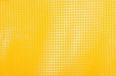 Parlak plastik doku kapatın. Arka plan olarak sarı kare yüzey.