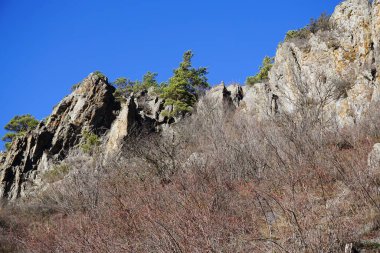 Guloyhi Vadisi 'ndeki akşam dağları ve kayalık tepelerin manzarası. Kuzey Kafkasya' nın Ingushetia kentindeki yüksek dağlık Dzheyra-Assinsky doğal müzesinde mavi gökyüzü.