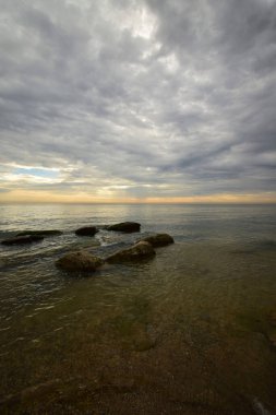  Hazar Denizi 'nin sabah manzarası pembe-turuncu gökyüzü, dalgalar ve kayalar Kafkasya' nın eteklerinde                              