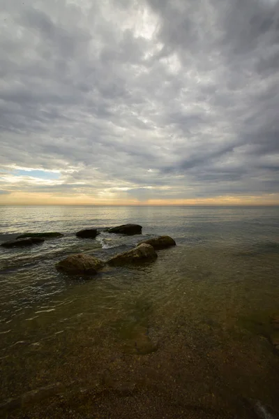  Hazar Denizi 'nin sabah manzarası pembe-turuncu gökyüzü, dalgalar ve kayalar Kafkasya' nın eteklerinde                              