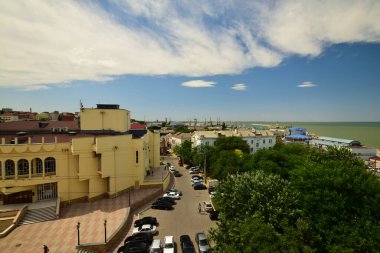 MAKHACHKALA, DAGESTAN REPUBLIC, RUSSIA - 20 Haziran 2018: Mavi gökyüzü, şehir binaları, dinlenme alanı ve plajı ile Hazar Denizi manzarası,                  