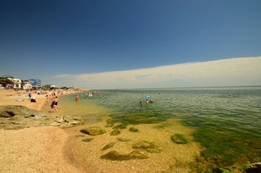  MAKHACHKALA, DAGESTAN, RUSSIA REUKLİK - 20 Haziran 2018: Hazar Denizi üzerinde insanlar ve mavi gökyüzü ile deniz yaz şehir plajı 