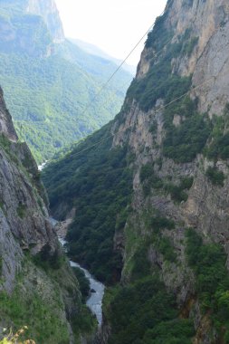  Kafkasya dağlarında bitkilerle dolu bir dağ geçidi ve bir nehir.                              