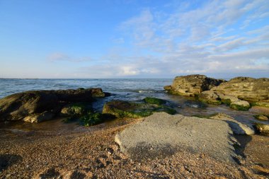   Hazar Denizi kıyılarının panoraması. Doğu Kafkasya kıyısında kumlu bir plaj ve mavi gökyüzü var.