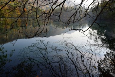 Kuzey Kafkasya 'nın dağlarındaki Cherek Vadisi' nde sonbaharda dalları olan karst mavi gölü manzarası                               